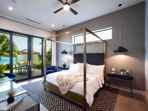 a bedroom with a canopy bed and a patio at Black Urchin Boutique Resort in Belford Estates