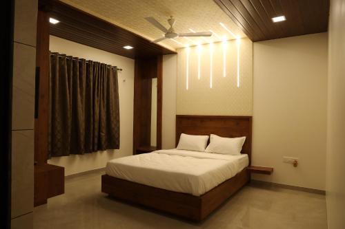 Schlafzimmer mit einem Bett und einem Deckenventilator in der Unterkunft Mahalaxmi Executive in Kolhapur
