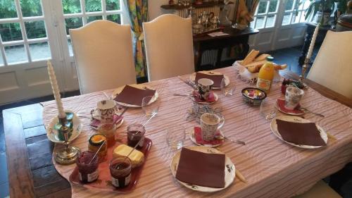 een eettafel met een roze tafelkleed bij la Maison d'Arbouet in Nanteuil-la-Fosse