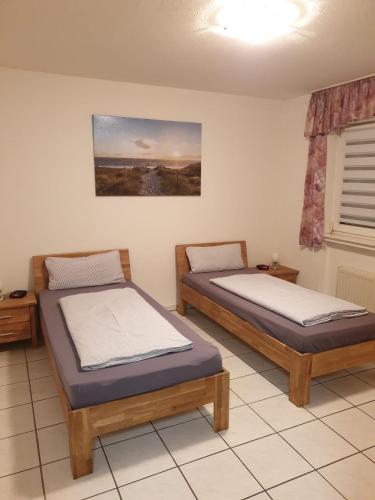 two twin beds in a room with a window at Ferienwohnung Calabria Nr 2 in Mülheim an der Ruhr