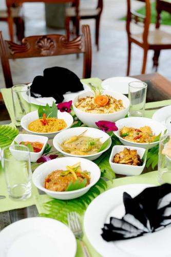 a table with white plates of food on it at Villa Birdlake in Hikkaduwa