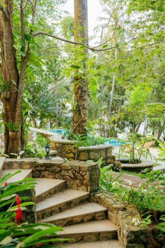 a stone staircase in a garden with trees at Villa Birdlake in Hikkaduwa