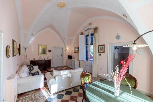 フランカヴィッラ・フォンターナにあるAgriturismo Tibitoneの白い家具とアーチ型の天井が備わるリビングルーム