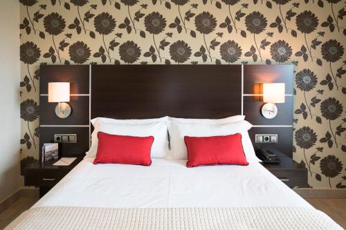 - une chambre avec un lit et 2 oreillers rouges dans l'établissement Hotel Piramide 2, à Portonovo