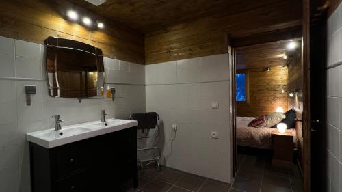 a bathroom with a sink and a bed at mini duplex dans chalet in Saint-François-Longchamp