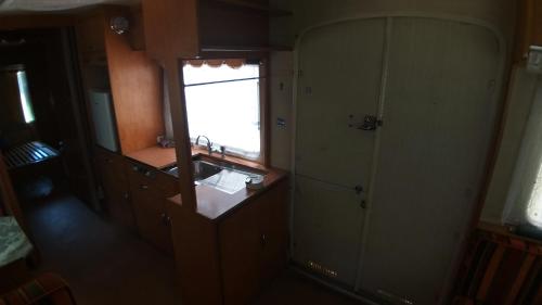 a kitchen with a sink and a mirror and a window at Erlebe unseren Verein im geräumigen Wohnwagen! in Feldkirchen bei Graz