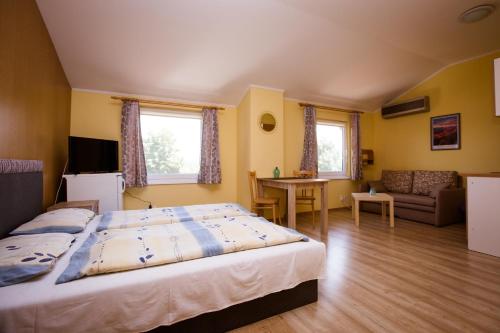 1 dormitorio con 1 cama y sala de estar en Penzion Adriana, en Patince