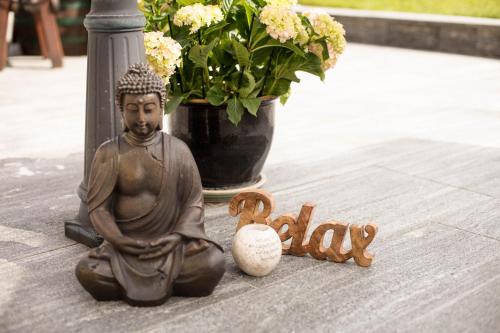 a statue of a buddha sitting on the ground at Pension Knoll in Schörfling