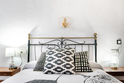 a bedroom with a bed with black and white pillows at Hostal "Los Chanos el Ruso" in Galende