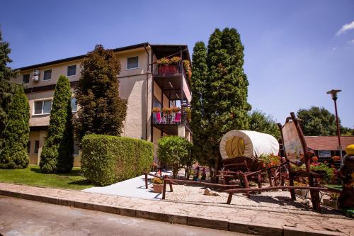 a building with a yard with chairs and trees at Penzion Adriana in Patince