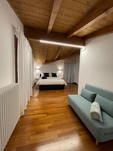 salon z kanapą i łóżkiem w pokoju w obiekcie B&B DA NONNA ANACLE w mieście Bastia Umbra