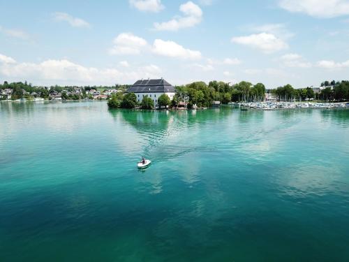 a person in a boat on a large lake at Pension Knoll in Schörfling