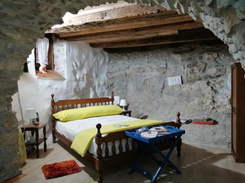 1 dormitorio con 1 cama en una pared de piedra en Tre metr sopra il cielo '' girasoli'', en Felitto