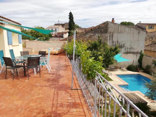 a balcony with a table and chairs and a swimming pool at La Terrasse in Gignac