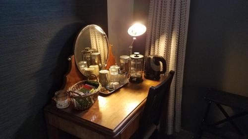 a dressing table with a mirror and a lamp on it at Château Besson in Montluçon