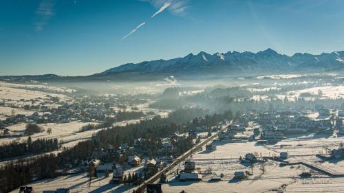 a view of a town in the snow with mountains at Dom Wypoczynkowy u Niedzielskich in Białka Tatrzanska