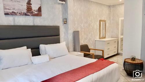 um quarto com uma grande cama branca e um cobertor vermelho em 36 frere road shelly beach , margate em Margate