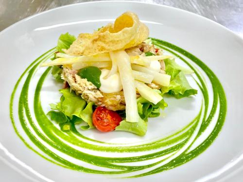 a plate of food with a salad on a table at Hotel Diana in Valdobbiadene