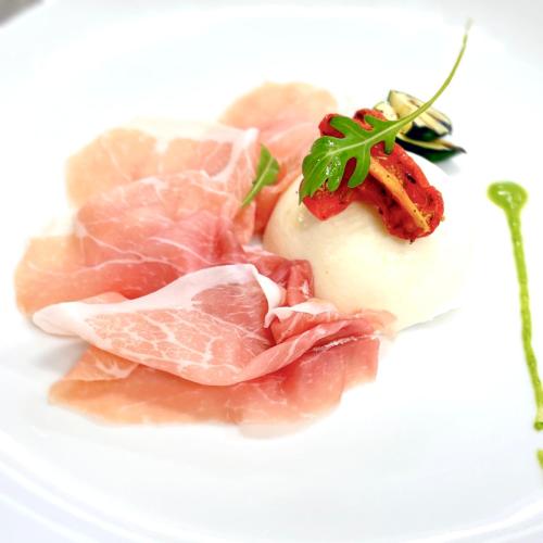 a plate of food with meat and a sauce at Hotel Diana in Valdobbiadene