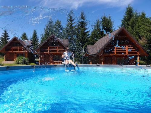 a person sitting in a chair in a swimming pool at Bieszczadzka Świteź in Baligród