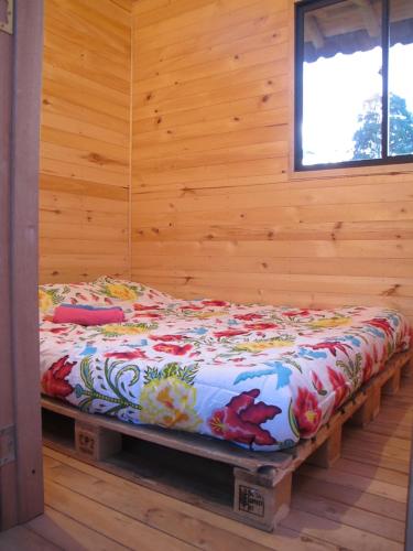 Cama en habitación con pared de madera en Crisantema 2, en Santa Elena