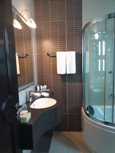 a bathroom with a sink and a shower at Costa Del Sol Hotel by Arabian Link in Kuwait
