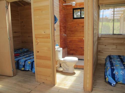 a cabin with a toilet and two beds in it at Crisantema 2 in Santa Elena