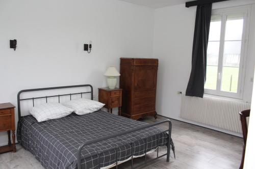 een slaapkamer met een bed, een dressoir en een raam bij LE TILLEUL in Saint-Ouen-du-Tilleul