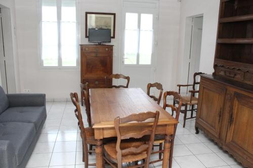 een woonkamer met een houten tafel en een bank bij LE TILLEUL in Saint-Ouen-du-Tilleul