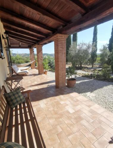 a patio with a wooden pergola and a bench at Casale Terre Rosse Garden in Saturnia