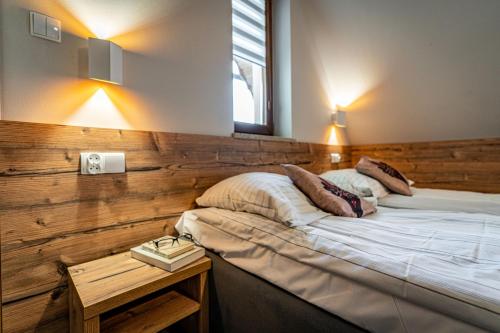 a bedroom with a bed with a wooden wall at Dom Wypoczynkowy u Niedzielskich in Białka Tatrzanska