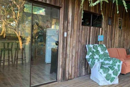 a room with a sliding glass door and a chair at Container Encantada in Garopaba