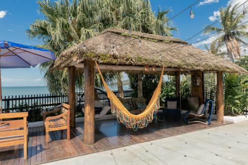 a gazebo with a hammock and chairs at Hotel Villareal São Francisco do Sul in São Francisco do Sul