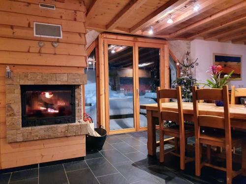 a dining room with a fireplace and a table and chairs at Le Valombré in Saint-Pierre-de-Chartreuse