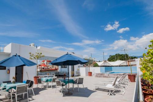 a patio with tables and chairs and umbrellas at Suites de La Parra in Oaxaca City
