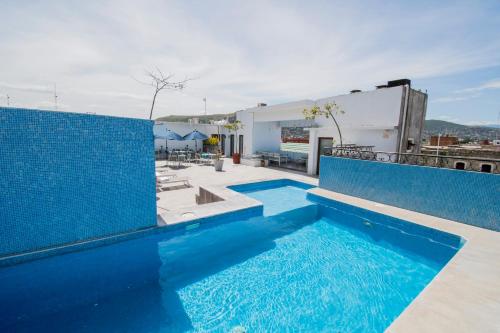 a swimming pool with blue tiles on a building at Suites de La Parra in Oaxaca City