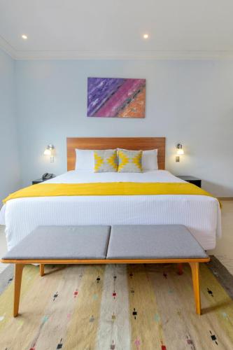 a bedroom with a large bed and a wooden floor at Suites de La Parra in Oaxaca City