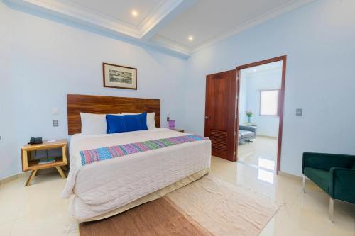 a bedroom with a large bed and a chair at Suites de La Parra in Oaxaca City