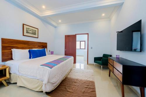 a bedroom with a bed and a flat screen tv at Suites de La Parra in Oaxaca City