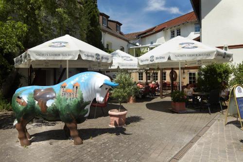 a statue of a cow in a courtyard with umbrellas at Zum Ochsen in Hauenstein