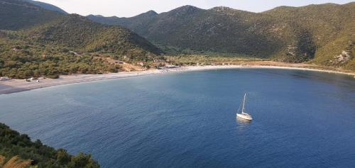 a boat in a body of water next to a beach at Amygdalia, a Stone House in a quiet landscape in Leonidion