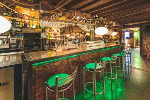 a bar with green stools in a restaurant at Hostal "Los Chanos el Ruso" in Galende