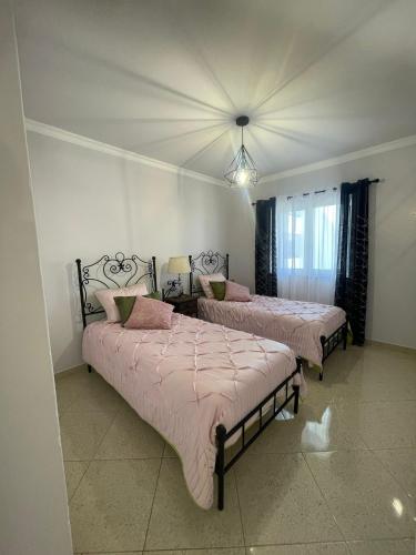 a bedroom with two beds with pink blankets at Alojamento King´s Village in Albufeira