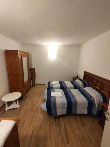 a bedroom with two beds and a table in it at CASA LA FALEGNAMERIA in Bivigliano