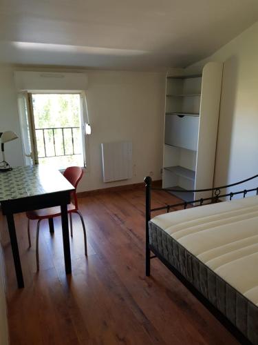 une chambre avec un lit, un bureau et une fenêtre dans l'établissement F4 dans maison au calme près du centre de Chalons en champagne, à Châlons-en-Champagne