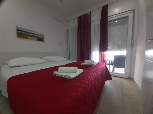 um quarto com uma cama vermelha e toalhas em Omiš Apartmani Mouse em Omiš