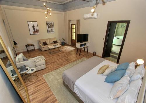 a bedroom with a large bed and a living room at Casa Florencia Hotel Boutique in Guanajuato