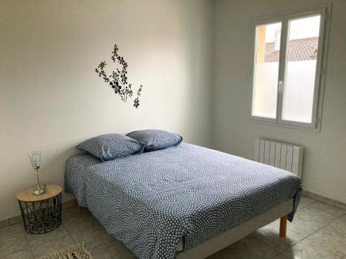 1 dormitorio con 1 cama con una flor en la pared en LE 30, en Cognac