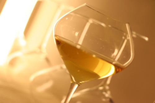 a glass of white wine sitting on a table at Hotel Vittoria in Rubano