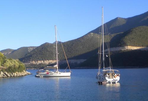 two boats sitting in a lake with mountains in the background at Amygdalia, a Stone House in a quiet landscape in Leonidion